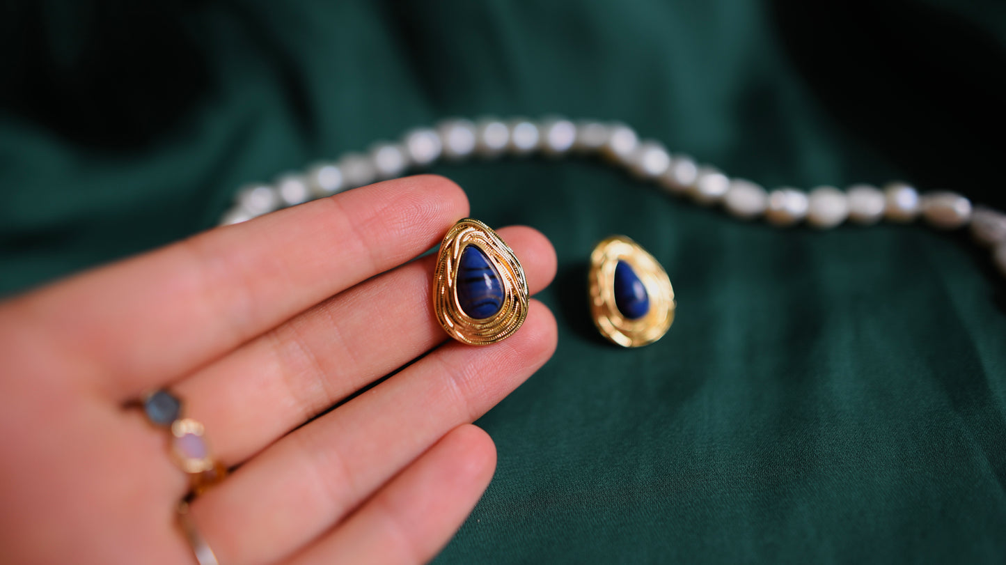 Goldene Ohrringe mit tiefblauem Stein